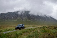 SUV on a road through the Scottish Highlands