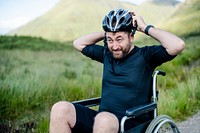 Handicapped man putting on a helmet