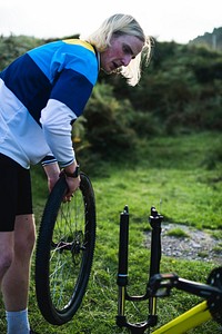 Male cyclist changing the wheels on his bike