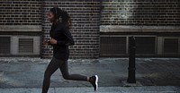 Woman listening to music while jogging in a city