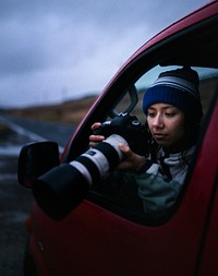 Woman taking a photo out of the car window