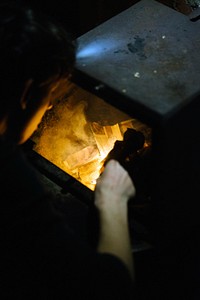 Man setting a fire in a fireplace