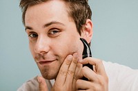 Young man trimming his beard