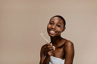 Black woman holding a wooden toothbrush