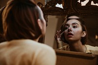 Woman looking in a mirror desolately