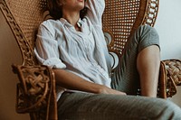 Woman relaxing on a vintage wicker chair