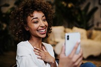 Cheerful black woman having a video call in her house