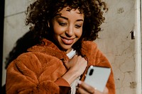 Cheerful black woman using her phone in downtown