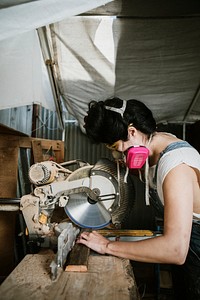 Female carpenter using a compound miter saw
