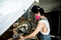 Female carpenter using a compound miter saw