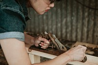 Female carpenter shaping lumber with a hand plane