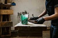 Female carpenter coating lumber with lacquer