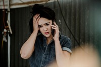 Female carpenter talking on a phone with worries