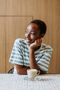 Black woman sitting cheerfully in a cafe