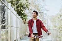 One caucasian man pushing his bicycle at park