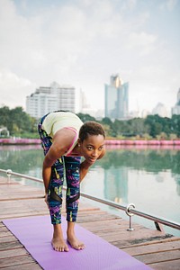 Black lady doing a yoga in a park