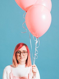 Woman holding a pastel pink balloon