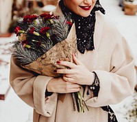 Happy woman holding a bouquet of flowers in the wintertime