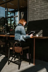 Woman using a digital tablet in a cafe