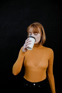 Woman in a turtleneck drinking from a takeout paper cup mockup
