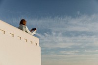 Woman capturing the Los Angeles view with her phone at the Griffith Observatory, USA