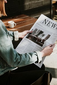 Woman reading a newspaper in a cafe