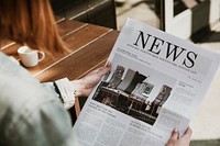 Woman reading a newspaper in a cafe