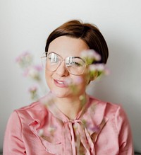 Cheerful woman in a pink shirt holding waxflowers