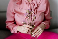 Woman in pink holding waxflowers