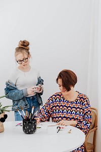 Female artist painting while her daughter is watching