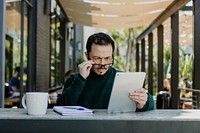 Stressful man using a tablet in a cafe