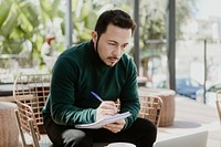 Businessman writing in a notebook in a cafe