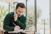 Man taking notes while talking on the phone