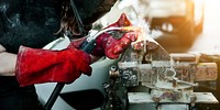 Female welding a metal piece in the garage