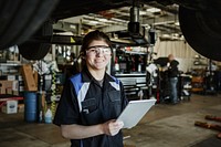 Happy mechanic running a diagnostic on a vehicle