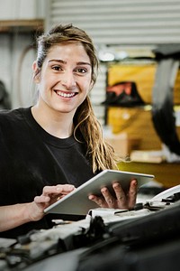 Female mechanic running a diagnostic on a car engine