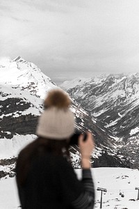 Photographer capturing the view of snowy mountains