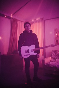 Man with a guitar vibes from a music video shoot