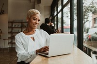 Happy businesswoman in a cafe using her laptop