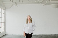 Senior woman standing in an empty white room