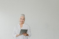 Senior woman using a digital tablet in a white room