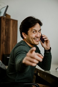 Happy man pointing and talking on the phone