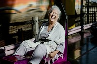 Cheerful senior woman on a bumper car in an amusement park