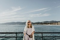 Senior woman standing the by the pier