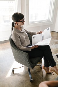 Young businesswoman reading a newspaper