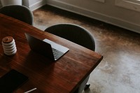 Digital tablet and a laptop on a wooden table in a meeting room