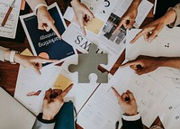 Business people pointing at a puzzle piece