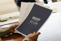 Businesswoman holding paper mockups in the meeting room