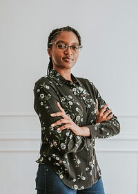 Happy empowering black woman standing by a white wall