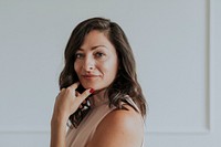 Happy woman standing by a white wall